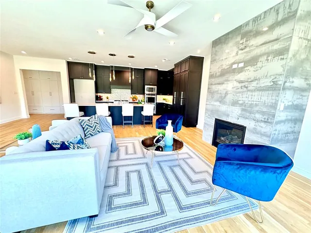 a living room with furniture kitchen view and a large window