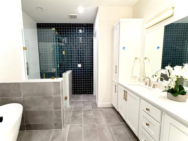 a bathroom with a tub sink and mirror