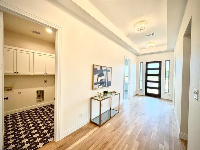 a view of a hallway with wooden floor and windows