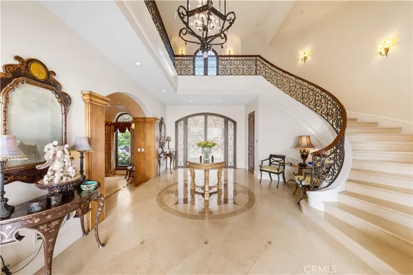 a dining room with furniture a chandelier and a large window