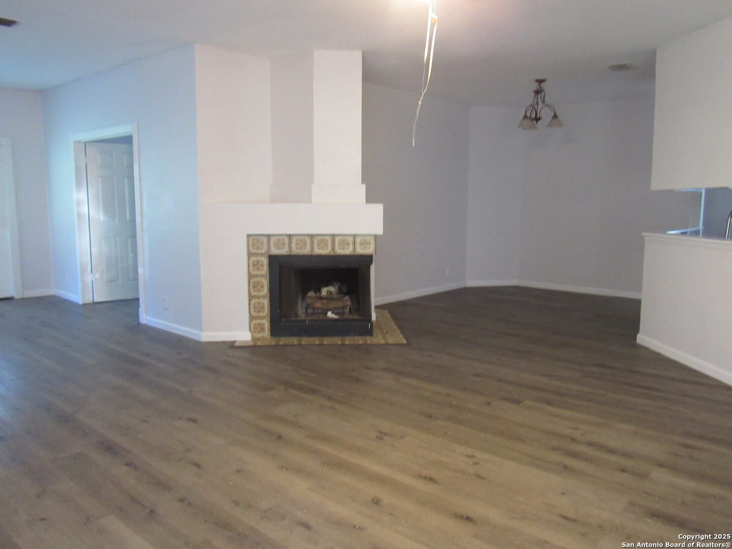 7731 Clear Ridge Drive San Antonio, TX 78239 - Photo 13 of 54 a view of an empty room with wooden floor and a fireplace