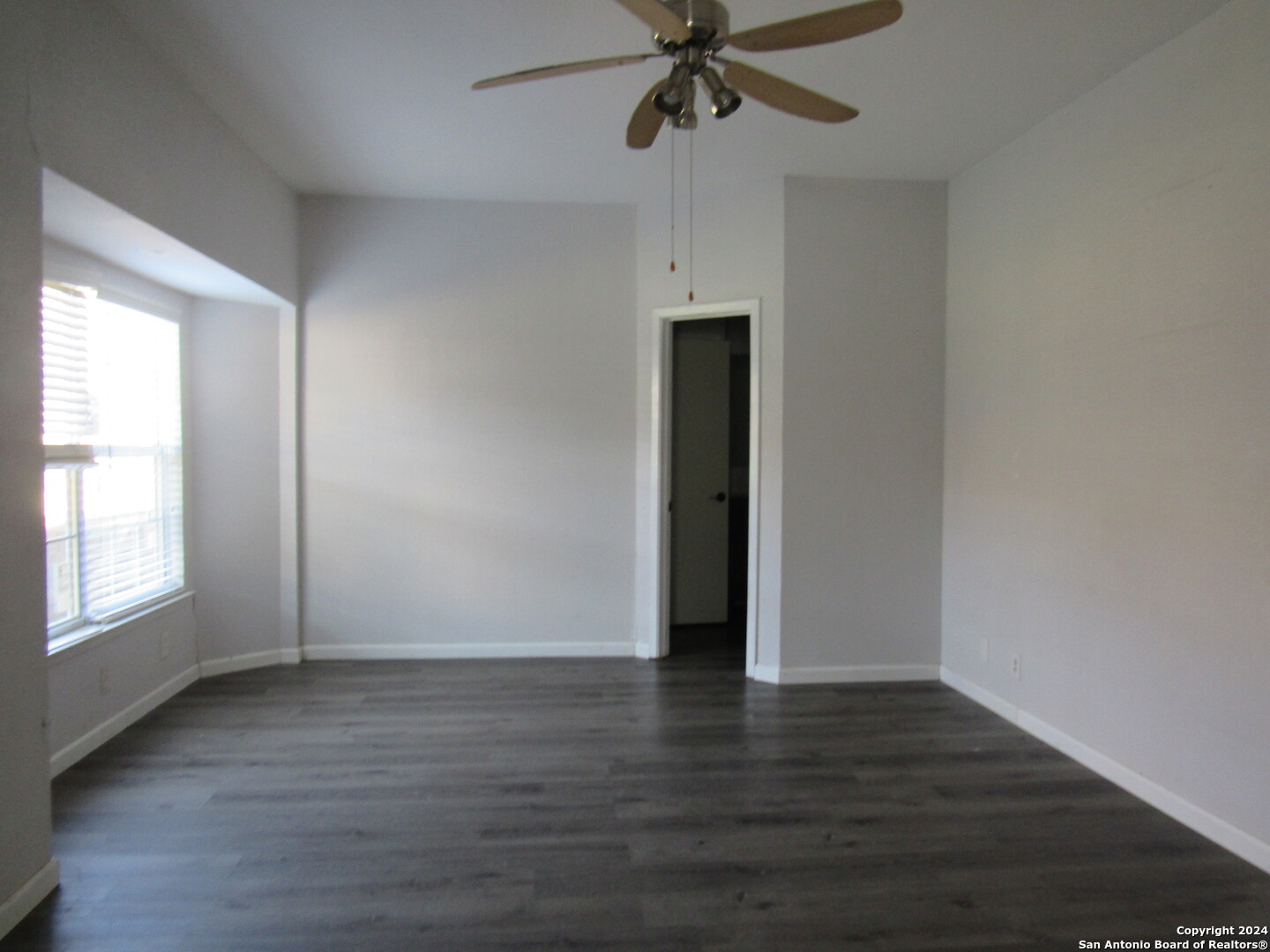 7731 Clear Ridge Drive San Antonio, TX 78239 - Photo 24 of 54 an empty room with wooden floor fan and windows