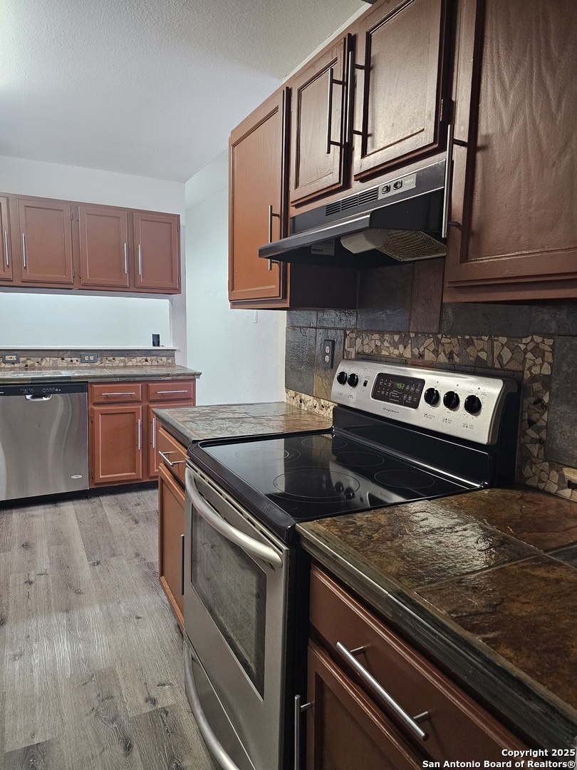 7731 Clear Ridge Drive San Antonio, TX 78239 - Photo 30 of 54 a kitchen with stainless steel appliances granite countertop a stove and a microwave