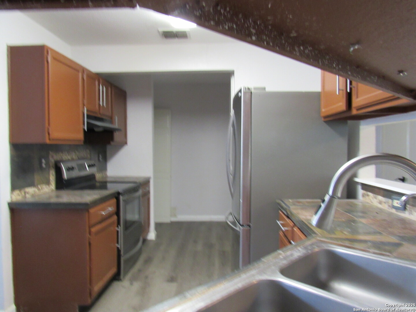 7731 Clear Ridge Drive San Antonio, TX 78239 - Photo 32 of 54 a kitchen with stainless steel appliances granite countertop a sink a stove and a refrigerator