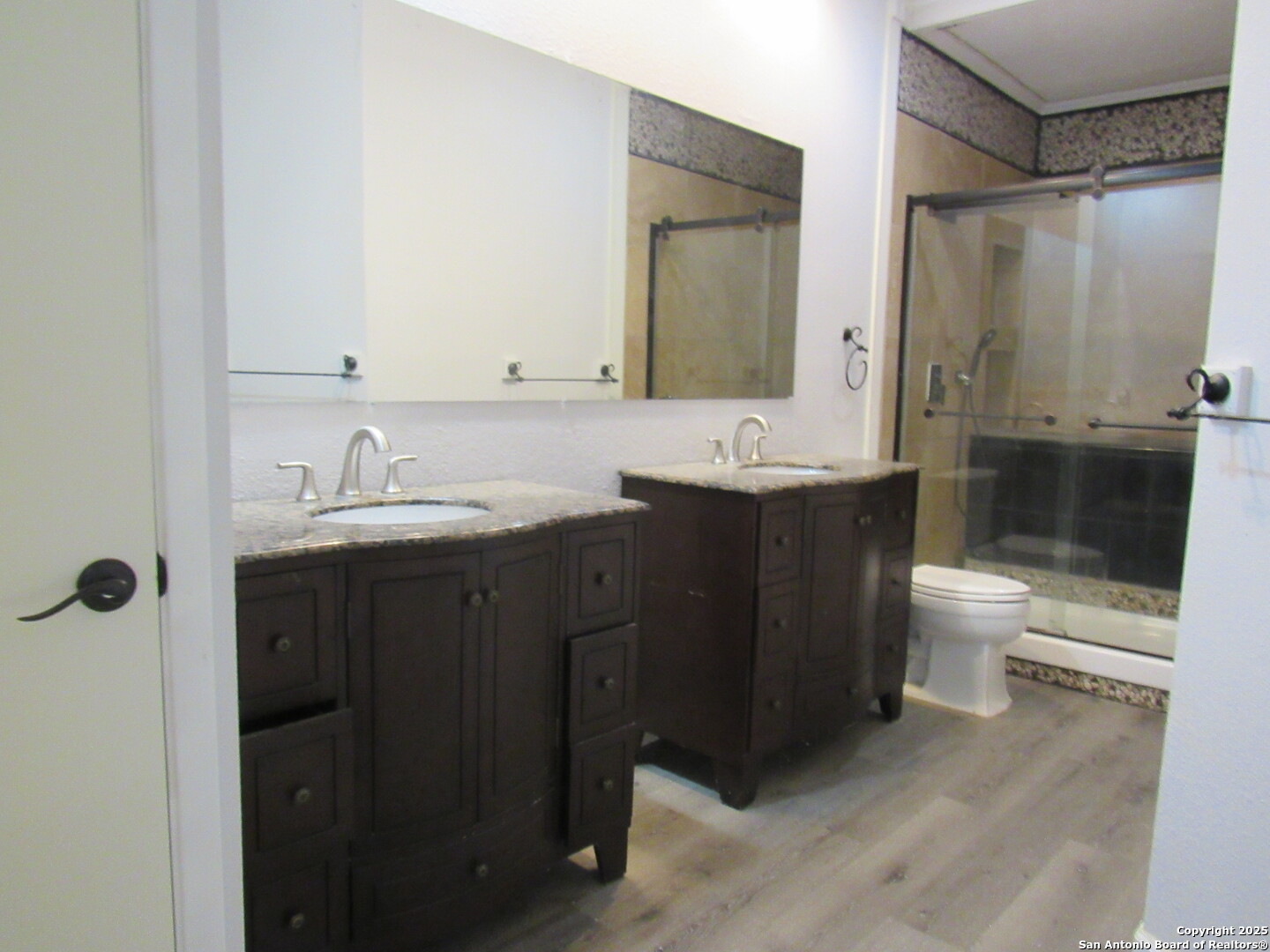 7731 Clear Ridge Drive San Antonio, TX 78239 - Photo 37 of 54 a bathroom with a double vanity sink toilet mirror and shower