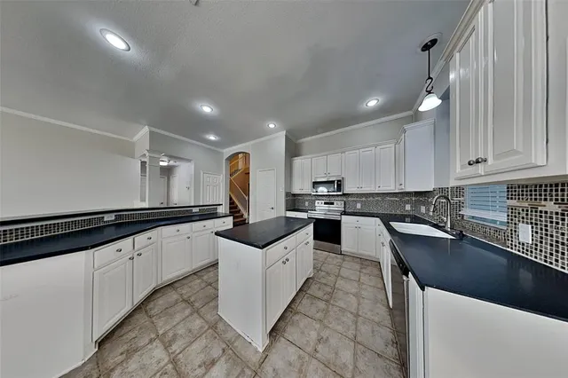 a kitchen with granite countertop a sink and cabinets