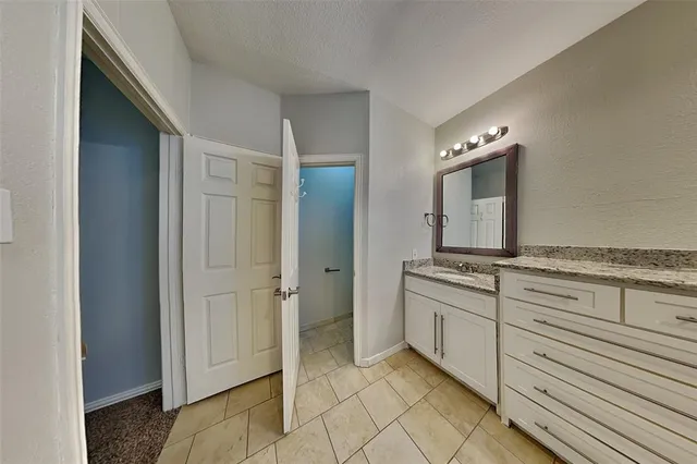 a spacious bathroom with a granite countertop sink mirror and shower