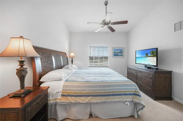 a bedroom with a bed and a flat tv screen on dresser