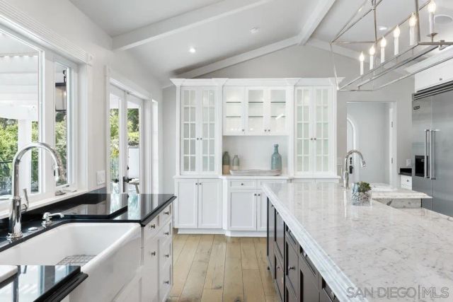 a large kitchen with kitchen island a large counter space a sink a window and stainless steel appliances