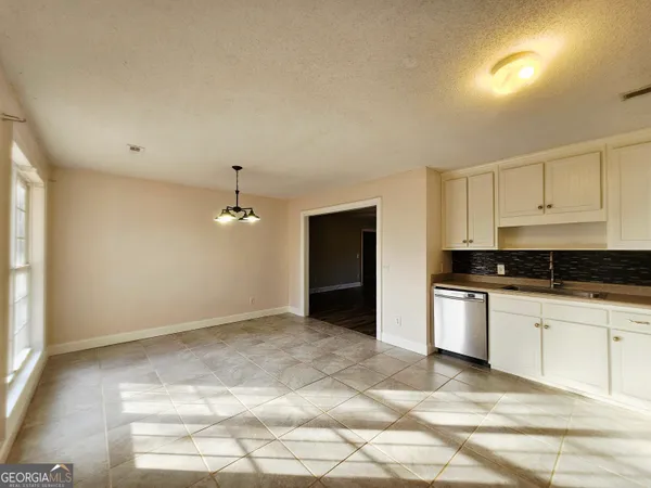 a kitchen with granite countertop a sink cabinets and stainless steel appliances