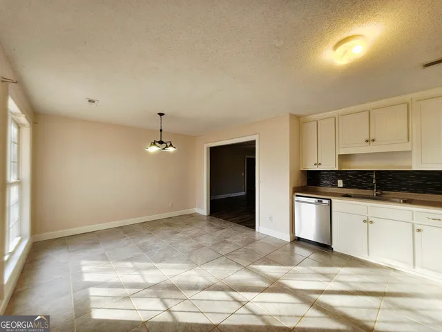 a kitchen with granite countertop a sink cabinets and stainless steel appliances