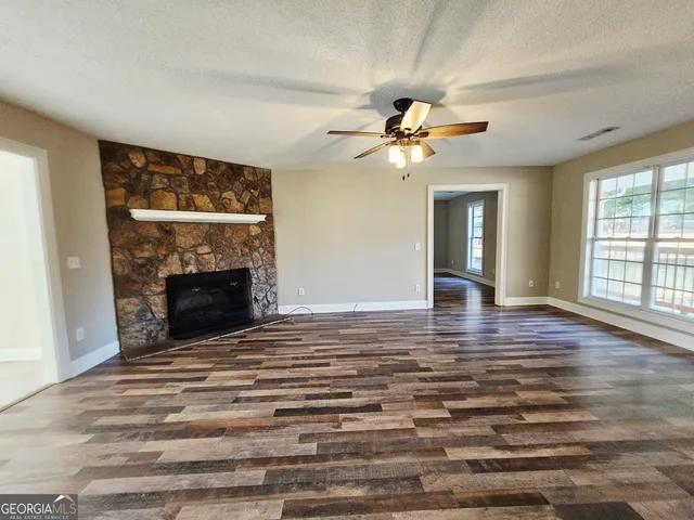 a view of an empty room with window and fireplace