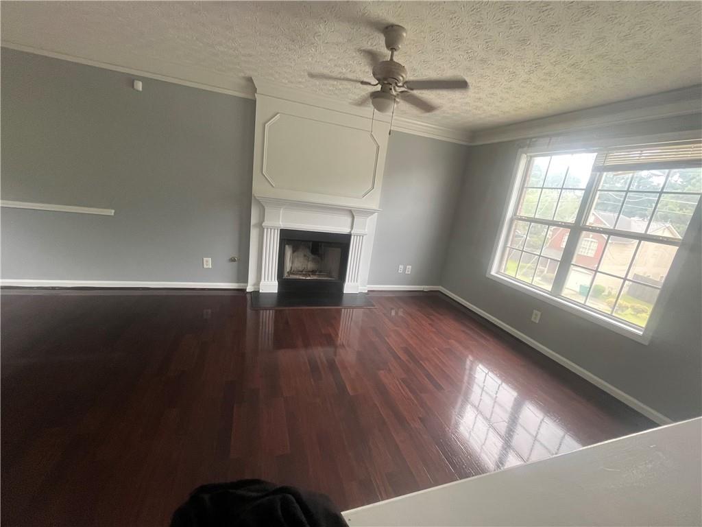 4170 Jewel Terrace Conley, GA 30288 - Photo 7 of 28 a view of an empty room with wooden floor fireplace and a window