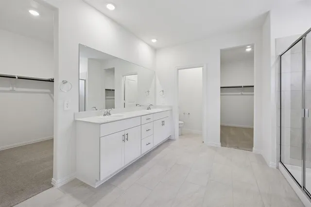 a spacious bathroom with a double vanity sink mirror and shower