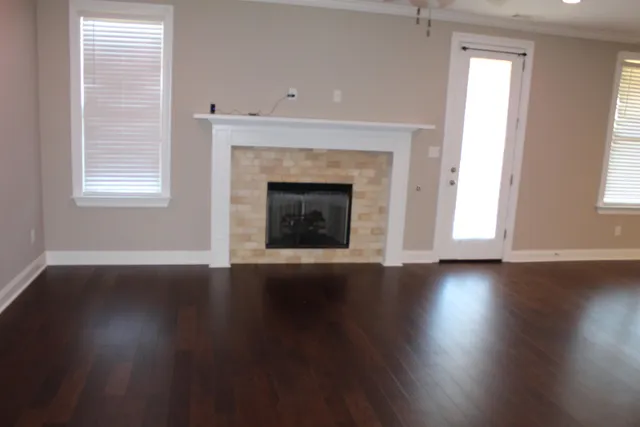 a view of a livingroom with wooden floor and a fireplace