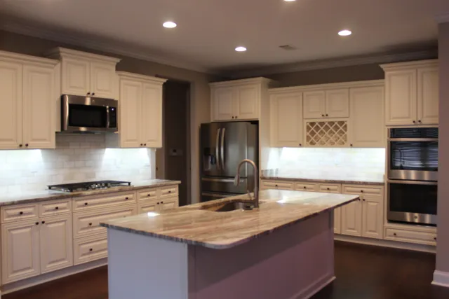 a kitchen with kitchen island granite countertop a sink stove and refrigerator