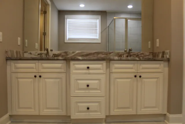 a bathroom with a granite countertop sink and a mirror
