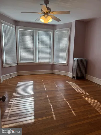 a view of empty room with windows and ceiling fan