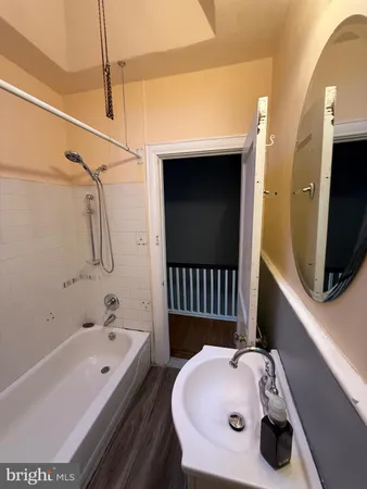a bathroom with a tub a sink and a mirror