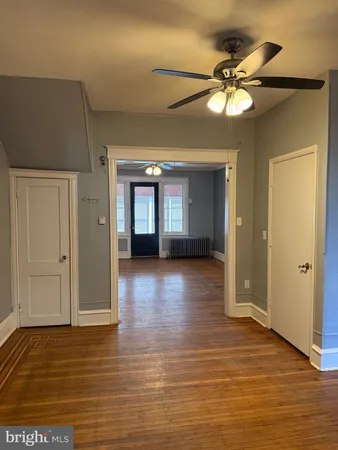 a view of a livingroom with a ceiling fan hardwood floor and a ceiling fan