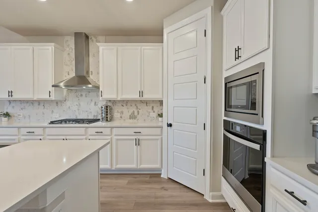 a kitchen with white cabinets and stainless steel appliances