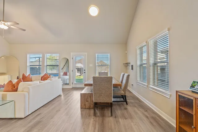 a living room with furniture a large window and wooden floor