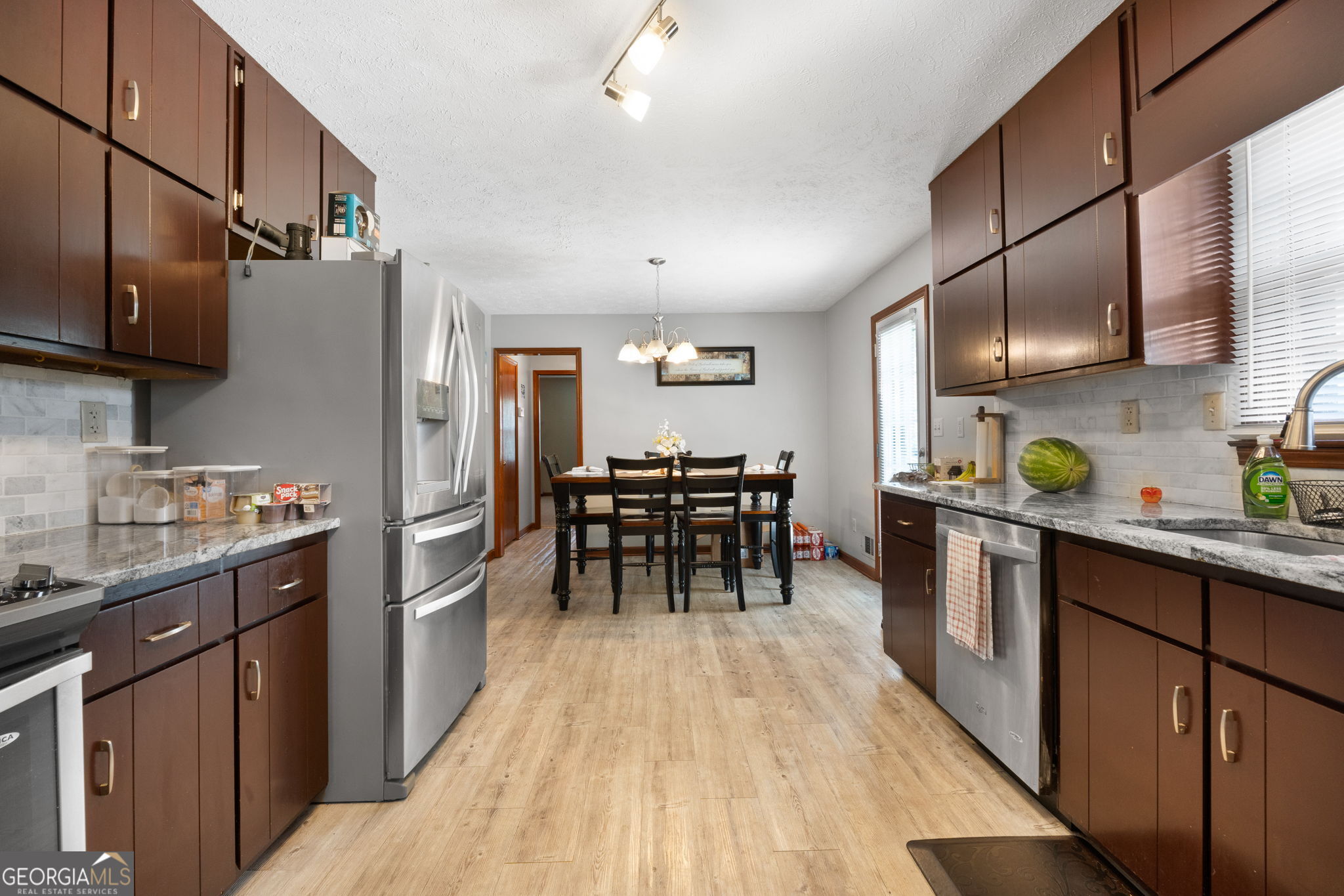 2050 North McDonough Road Griffin, GA 30223 - Photo 11 of 42 a kitchen with stainless steel appliances granite countertop a refrigerator a sink dishwasher a stove and a dining table with wooden floor