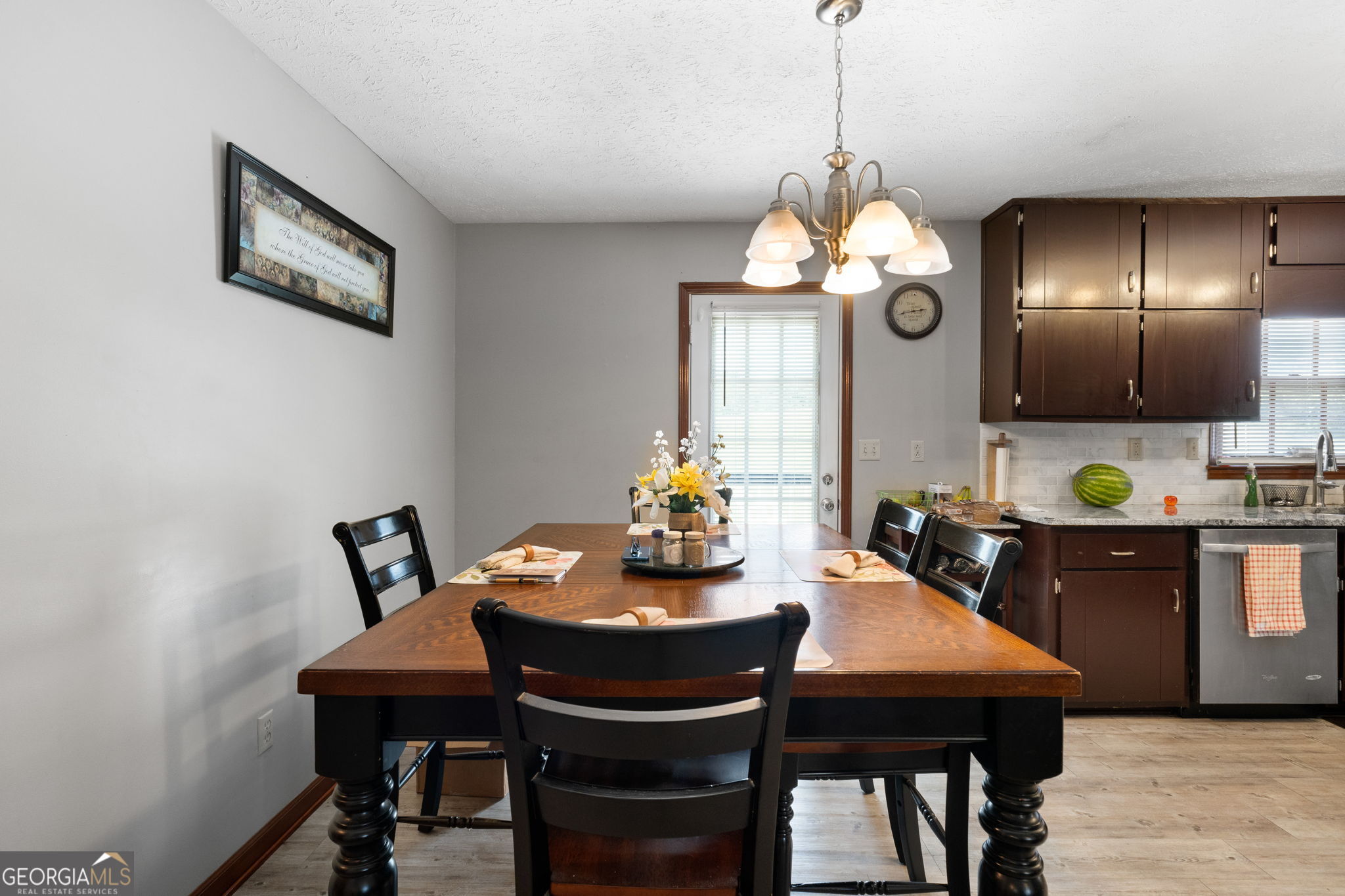 2050 North McDonough Road Griffin, GA 30223 - Photo 12 of 42 a dining room with wooden floor a chandelier a wooden table and chairs