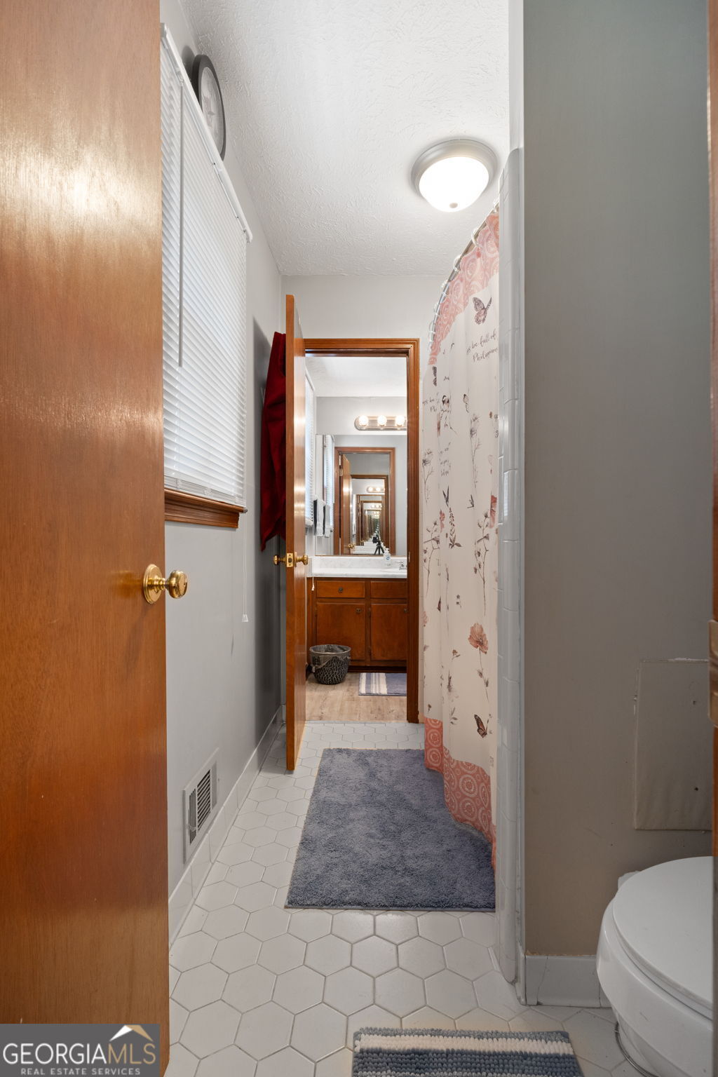 2050 North McDonough Road Griffin, GA 30223 - Photo 16 of 42 a bathroom with a granite countertop sink a toilet and shower