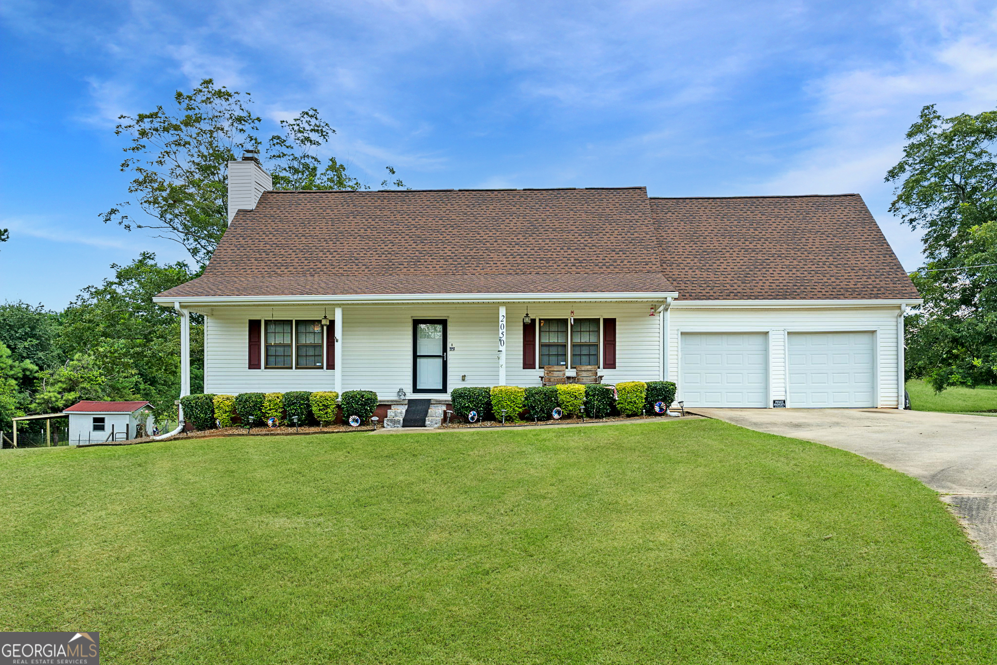 2050 North McDonough Road Griffin, GA 30223 - Photo 2 of 42 a front view of a house with a garden and trees
