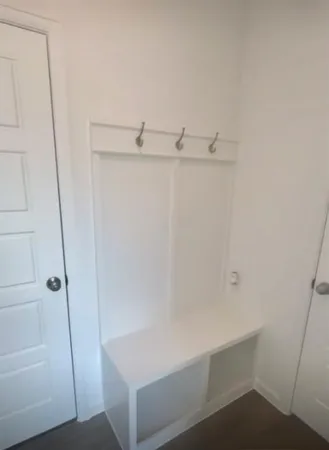 a view of a small space with wooden floor and a window