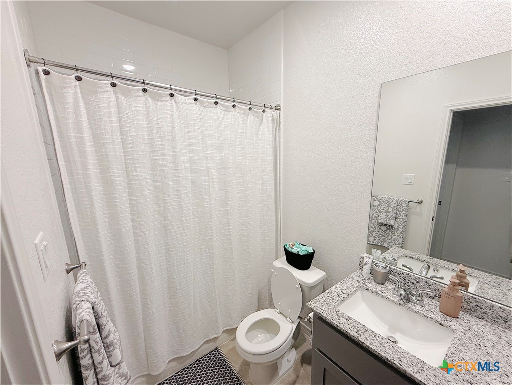 211 Riptide Road Temple, TX 76501 - Photo 9 of 11 a bathroom with a granite countertop sink and a mirror