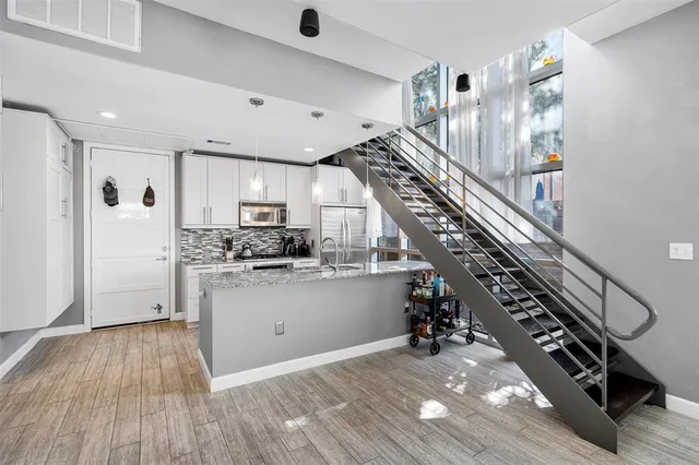 a view of a kitchen with wooden floor and stairs