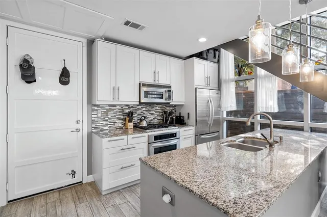 a kitchen with stainless steel appliances granite countertop a sink stove and refrigerator