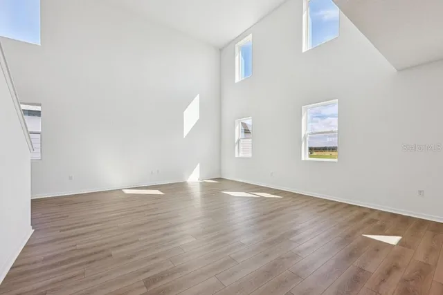 a large kitchen with stainless steel appliances kitchen island a large counter top and wooden floors