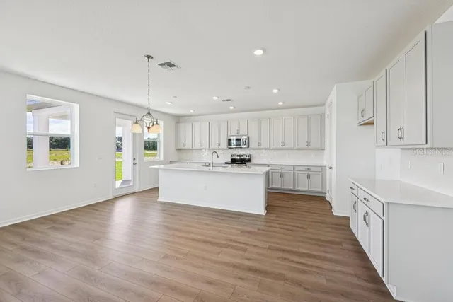 a kitchen with granite countertop a sink a stove cabinets and counter space