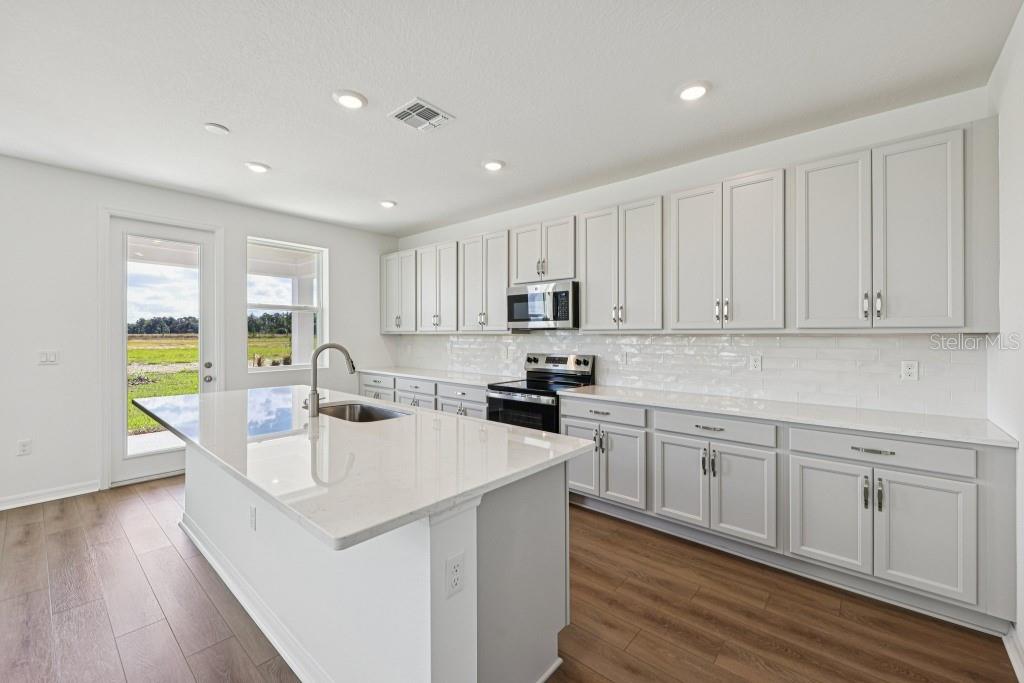 30121 Misty Pnes Road Mount Dora, FL 32757 - Photo 21 of 55 a kitchen with a sink cabinets and wooden floor