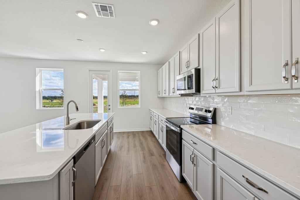 30121 Misty Pnes Road Mount Dora, FL 32757 - Photo 22 of 55 a kitchen with granite countertop a sink a stove cabinets and counter space
