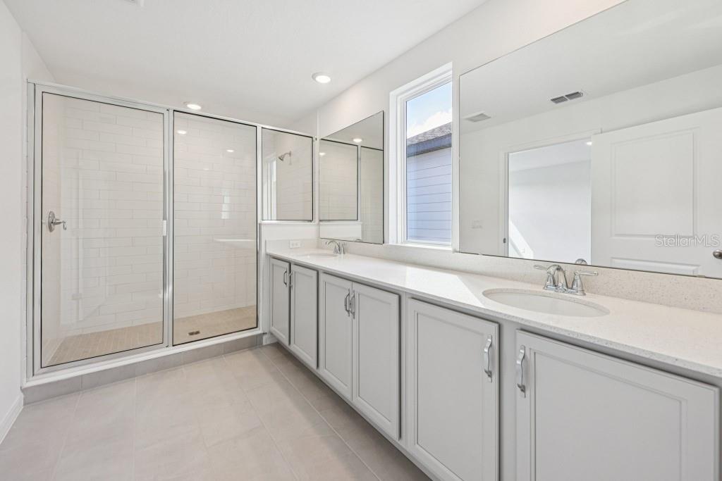 30121 Misty Pnes Road Mount Dora, FL 32757 - Photo 40 of 55 a bathroom with a double vanity sink and mirror
