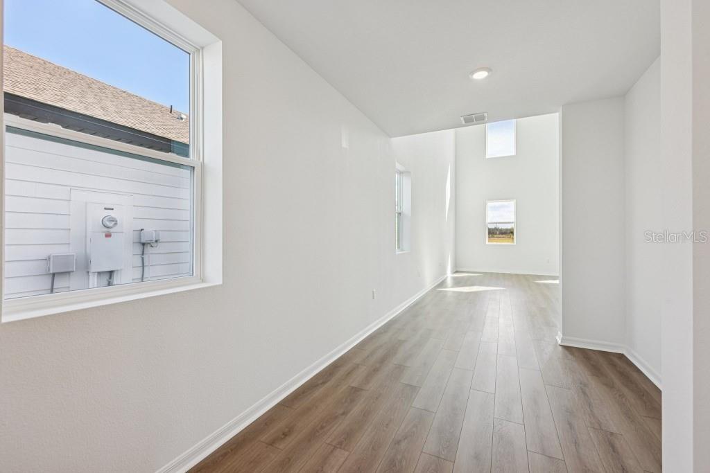30121 Misty Pnes Road Mount Dora, FL 32757 - Photo 7 of 55 a view of an empty room with wooden floor and a window