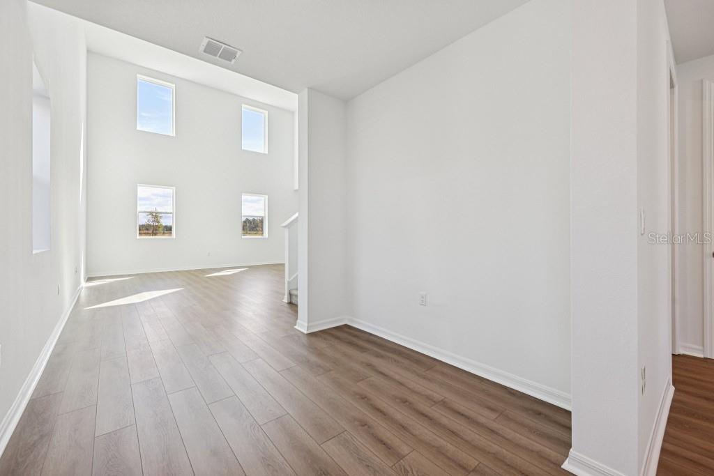 30121 Misty Pnes Road Mount Dora, FL 32757 - Photo 10 of 55 an empty room with wooden floor and windows