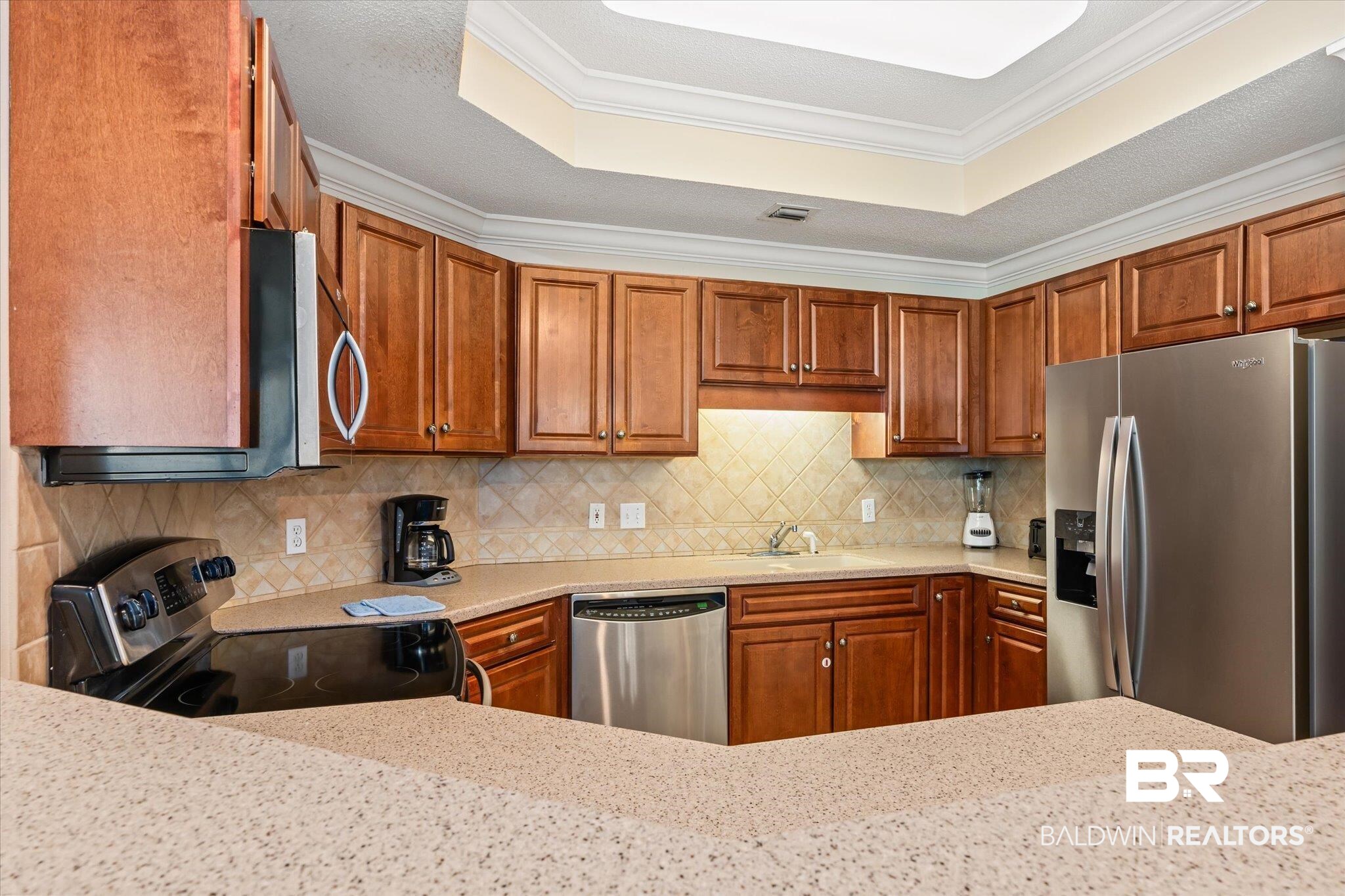 27580 Canal Road, Unit 1322 Orange Beach, AL 36561 - Photo 9 of 30 Kitchen with ornamental molding, appliances with stainless steel finishes, and a raised ceiling