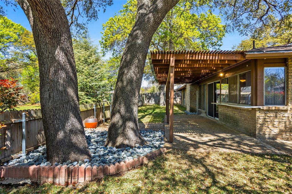 15721 Mapleview Circle Dallas, TX 75248 - Photo 31 of 40 a view of a small yard in front of a house with large trees and plants