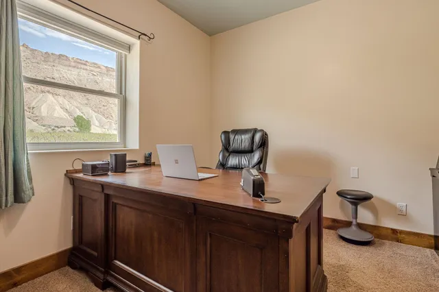 a view of a workspace with furniture and a window