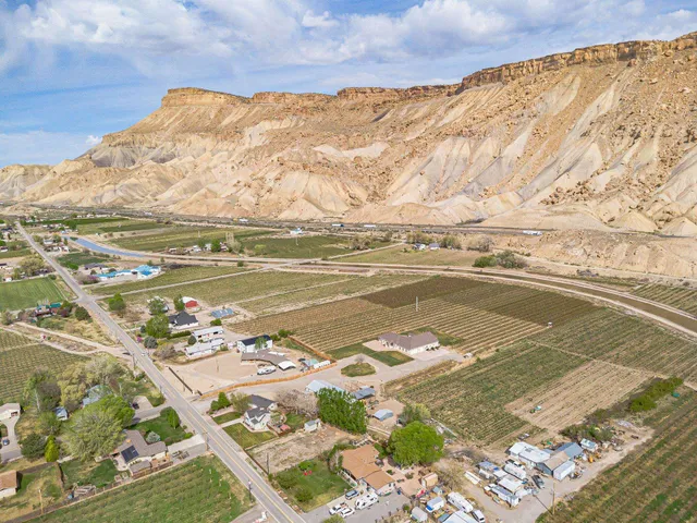 a view of a hallway with wooden floor and a bedroom