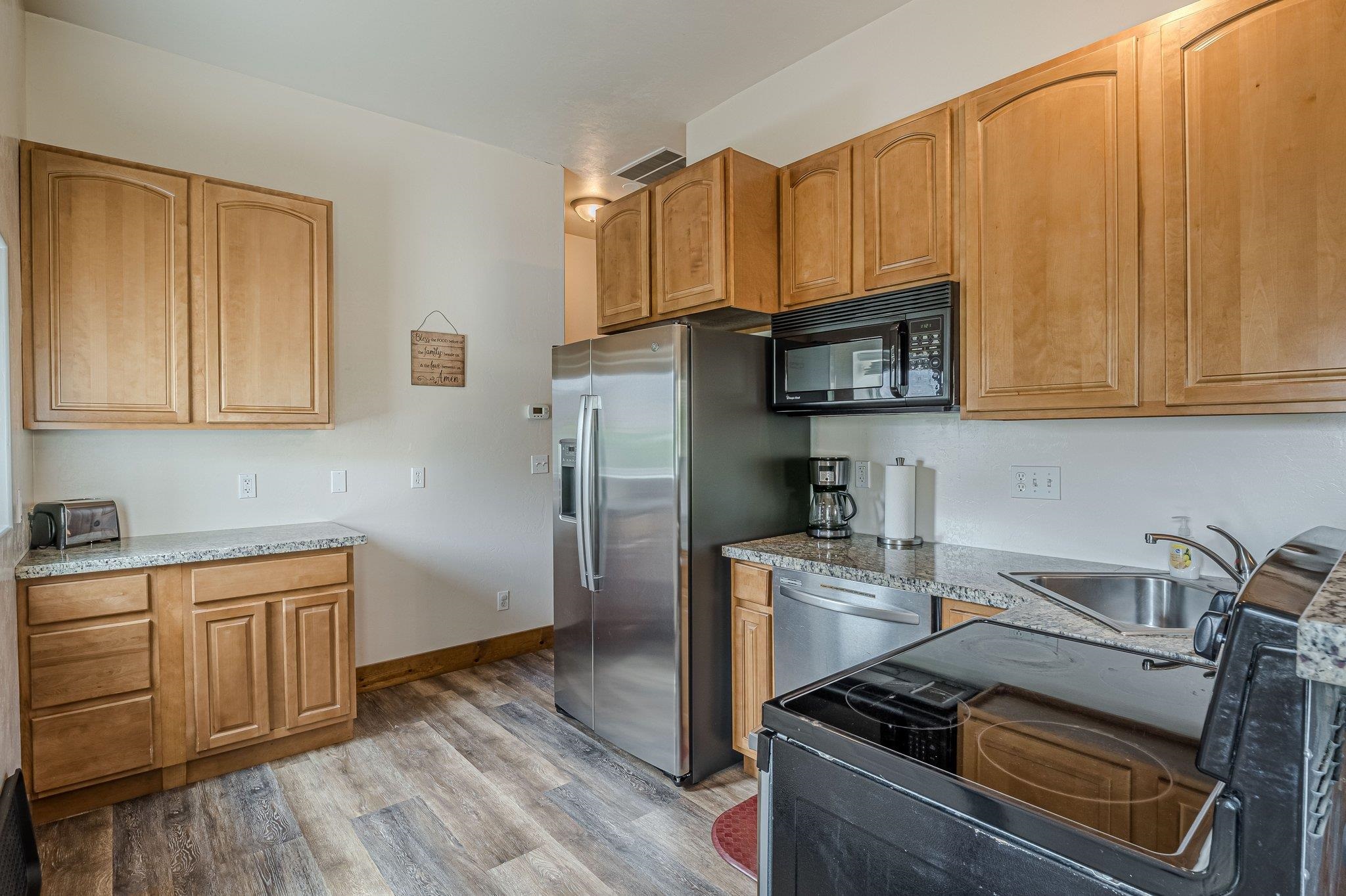 3652 1/2 G 7/10 Road Palisade, CO 81526 - Photo 37 of 42 a kitchen with stainless steel appliances granite countertop a stove top oven a sink dishwasher and cabinets with wooden floor