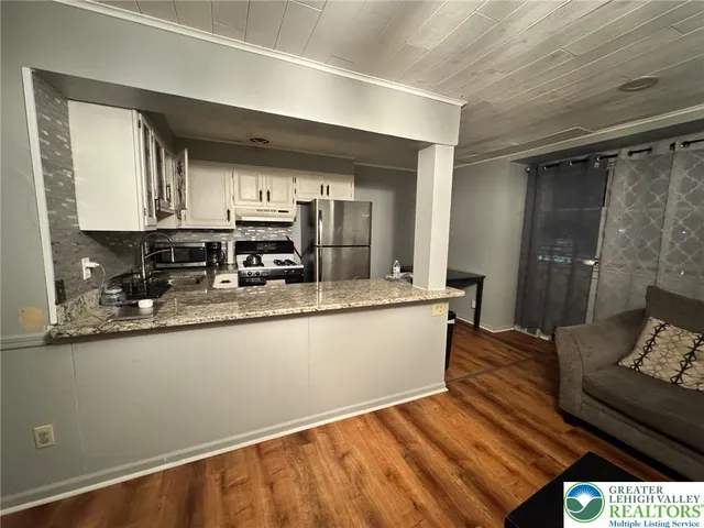 a kitchen with granite countertop a refrigerator and a sink