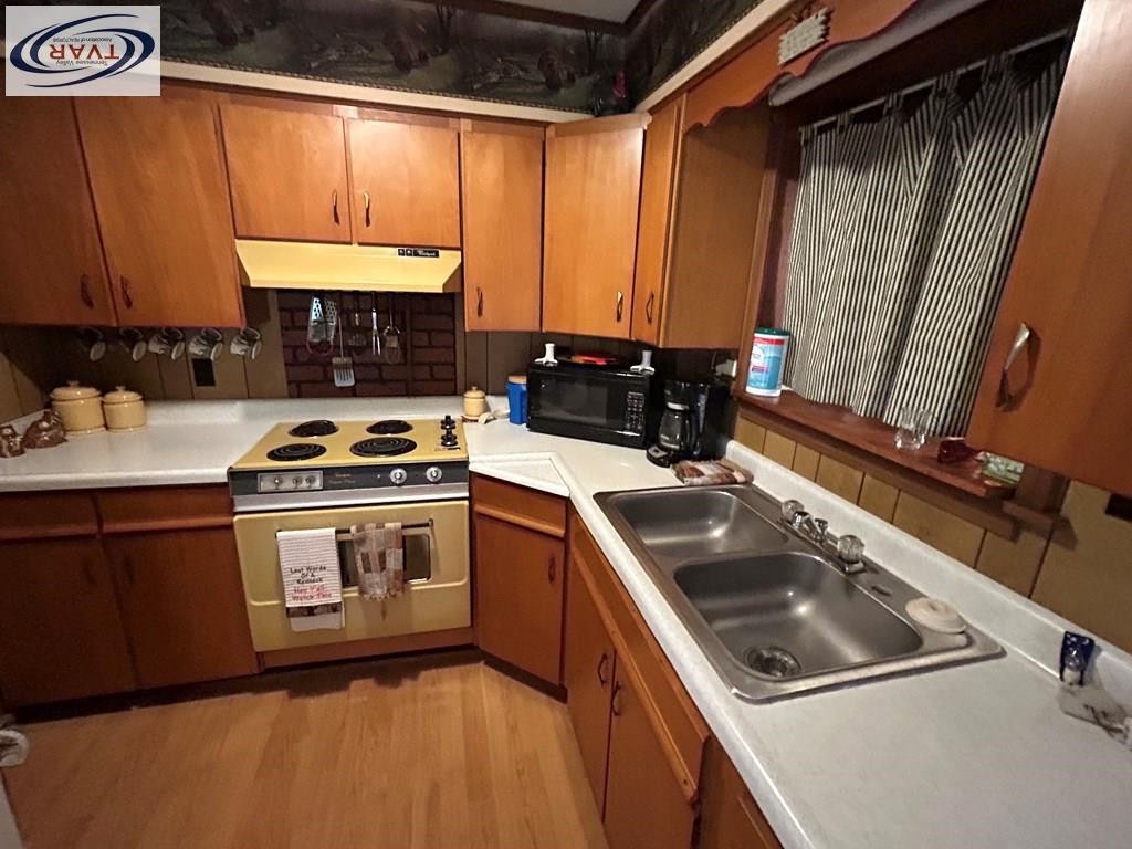 4460 Point Mason Road Big Sandy, TN 38221 - Photo 13 of 22 a kitchen with a sink stove and cabinets