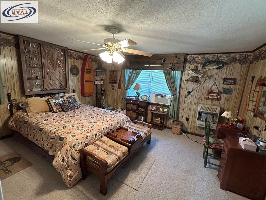 4460 Point Mason Road Big Sandy, TN 38221 - Photo 15 of 22 a bedroom with a bed a chandelier and a dresser
