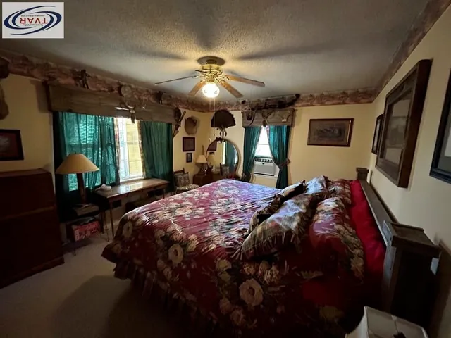 a bed sitting in a bedroom next to a window and a chandelier